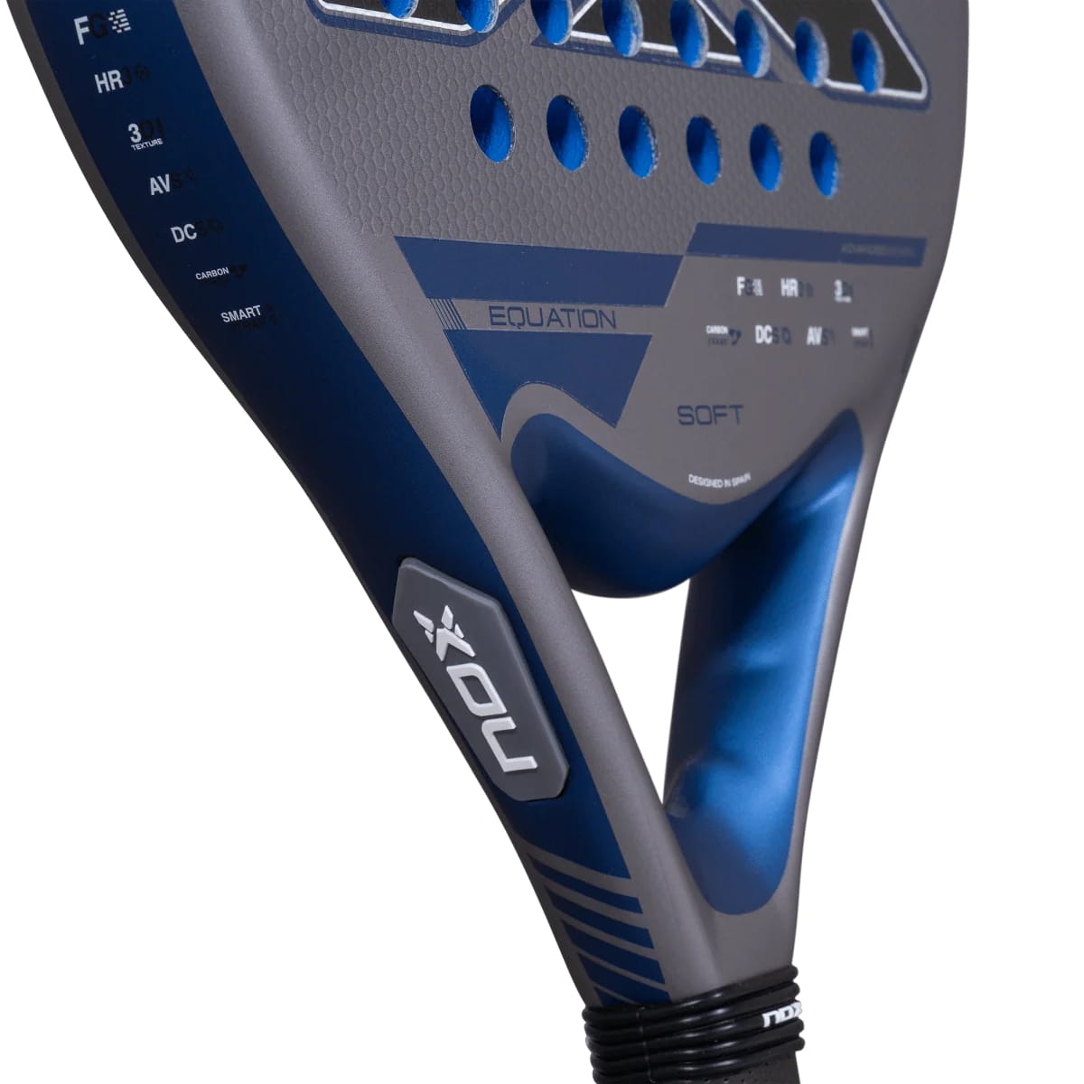 Close-up of a grey and blue NOX Equation Soft Advanced 2027 padel racket with a perforated face, showing the handle, bridge, and technical feature labels printed on the frame.