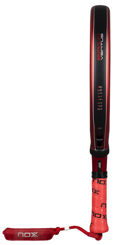 The NOX Luxury EA10 Ventus Hybrid 12K XTREM By Edu Alonso 2026 padel racket features a red and black design with a textured red grip, matching wrist strap, and "NOX" branding on both the grip and strap.