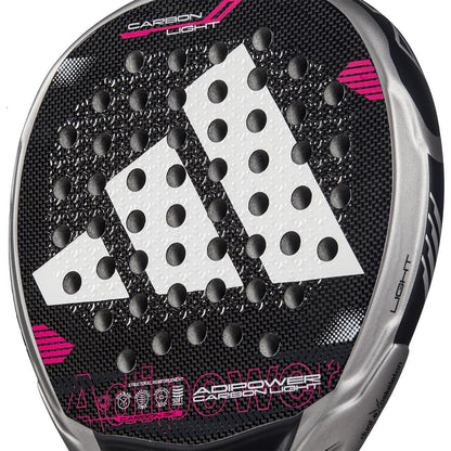Close-up of the ADIDAS Adipower Carbon Light 3.4 Padel Racket featuring Carbon 3K Fibre and a dotted pattern. The logo and branding are in white and pink, with partial "Adipower" text visible. A silver edge is labeled "Carbon Light," showcasing the innovative 3D Spin Blade Mold design.
