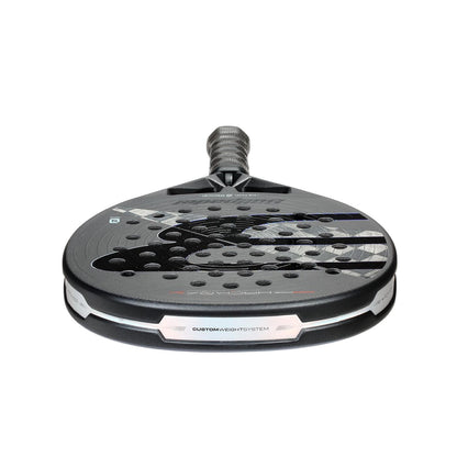 The Bullpadel HACK 04 Hybrid 2026 Padel Racket in grey and black is angled on a white background, showcasing its perforated face, textured surface, handle, and unique design details that emphasize the brand's dynamic power.