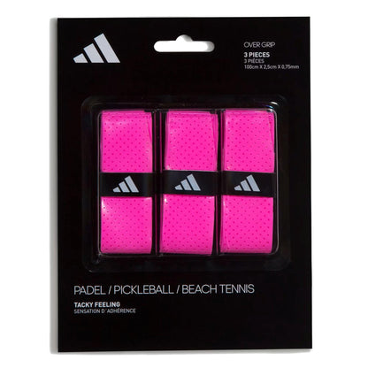 A black pack with white adidas branding contains three bright pink ADIDAS Padel Overgrips (3 Pack) - Pink, each with small perforations for comfort and performance in padel, pickleball, and beach tennis.