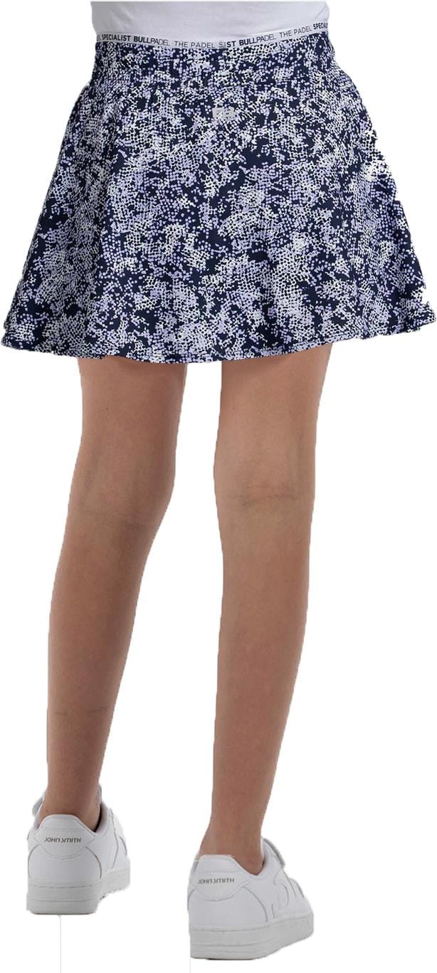 A person is shown from the back wearing the Bullpadel Parasil Women's Padel Skirt in Deep Ocean, paired with white sneakers and a white waistband, against a plain background.