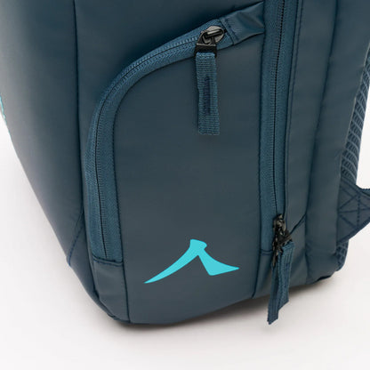 Close-up of the Kanso Intuko Padel 23L Backpack in navy showcasing a turquoise abstract logo with reflective print, featuring a zipper pocket and partial view of the shoulder strap against a neutral gray background.