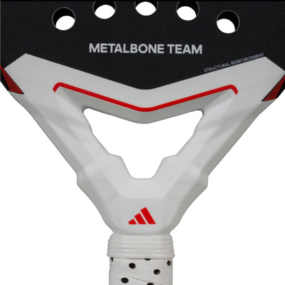 The ADIDAS Metalbone Team 3.4 Padel Racket features a black, red, and white design, ideal for advanced players. "METALBONE TEAM" and "STRUCTURAL REINFORCEMENT" appear on the top edge with a centered logo below and a sleek white grip tape on the handle.