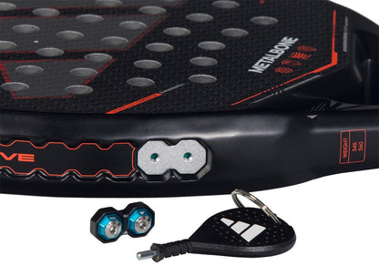 Close-up of the adidas Metalbone by Ale Galán 2026 Padel Racket in black, an adjustable-weight padel racket featuring two hexagonal weights with blue rings and a branded black keychain tool.