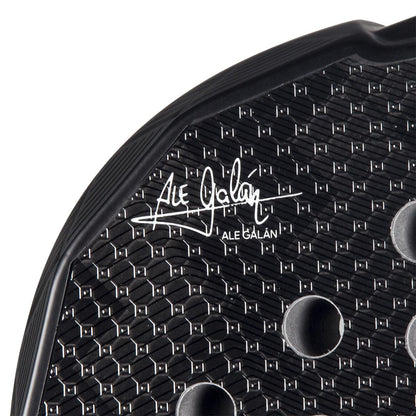 Close-up of the adidas Metalbone 3.4 Padel Racket - Black/White designed for advanced players, featuring a textured surface with hexagonal patterns and circular holes. The "Ale Galán" signature is prominently displayed, adding finesse to this precision-engineered masterpiece.