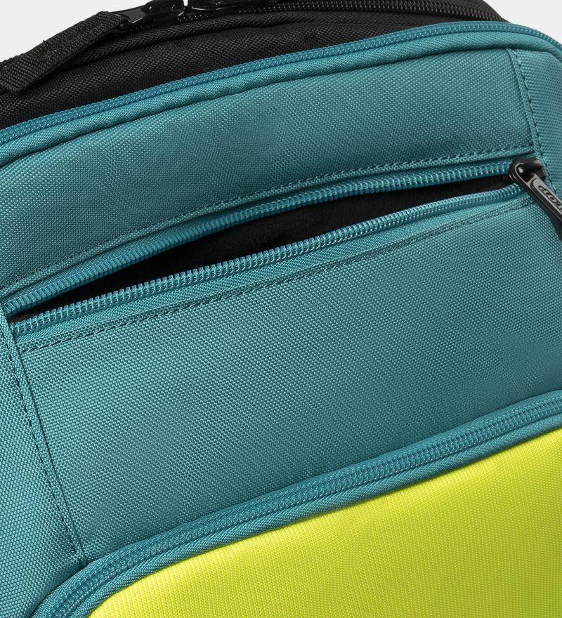 The close-up of the Dunlop SX Performance Padel Backpack highlights its two zippered compartments. The upper part is teal, and the lower is lime green, ideal for serious players. Black zippers with silver pulls complement the durable textured fabric.