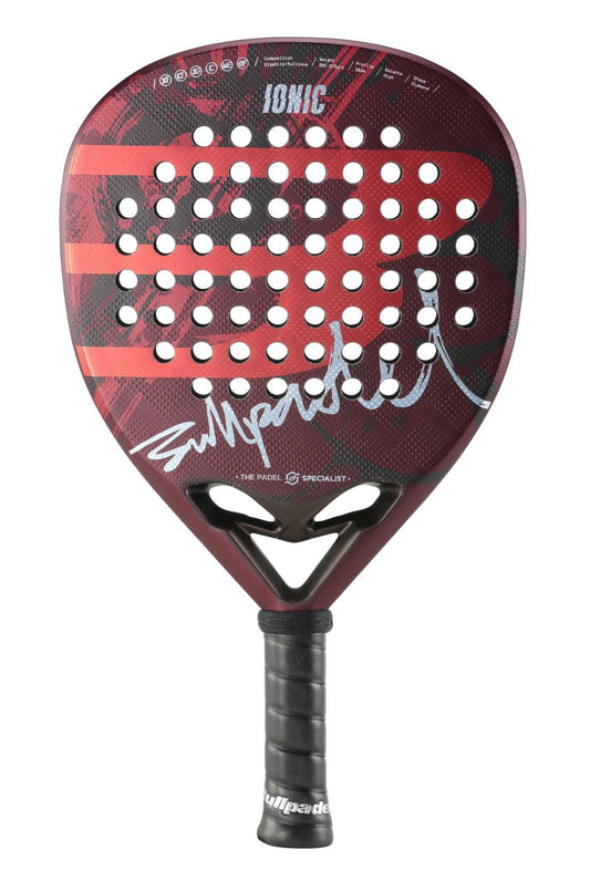 The Bullpadel Ionic Power 2024 Padel Racket - Red features a striking red and black color scheme with a perforated design. It boasts a Diamond Head Shape, complete with white branding and signatures on the face. The racket's performance is enhanced by the Multieva Core, while the handle is wrapped in black grip tape for superior control.