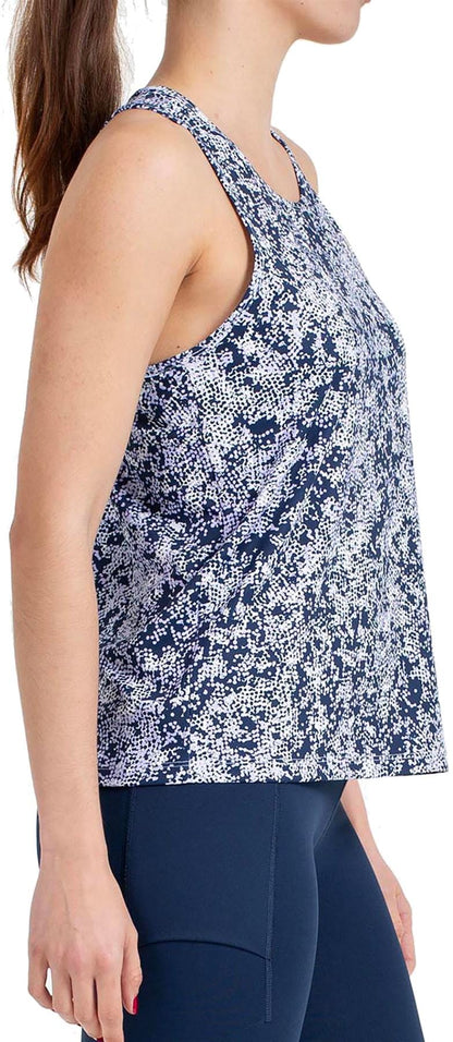 Woman in a Bullpadel Pilme Women's Padel Tank Top - Deep Ocean and navy leggings, standing in profile with her hair in a ponytail, showcases Bullpadel’s breathable sportswear ideal for high-performance activity.