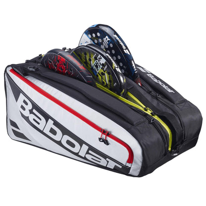 The Babolat RH Pro 4 Racket Padel Bag in black and silver is unzipped, revealing three rackets inside. This spacious bag has visible compartments and bold Babolat branding for organized storage.