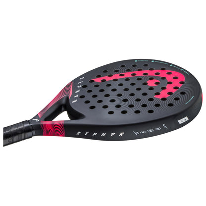 The HEAD Zephyr 2023 padel racket boasts a sophisticated black design complemented by vibrant pink accents and perforations. Its textured grip provides excellent control, while the Graphene 360+ technology and Power Foam enhance performance. The name "Zephyr" is prominently featured on the side.