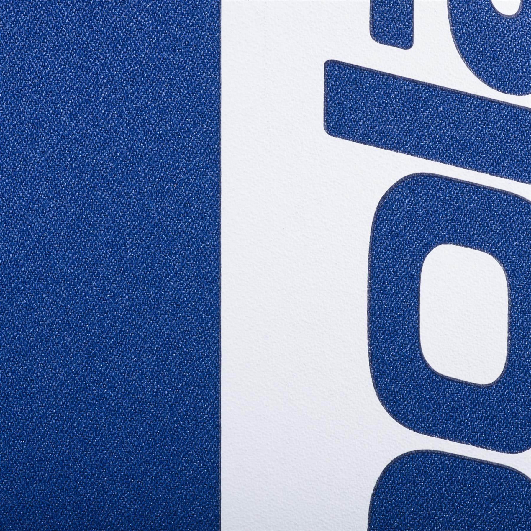 Close-up of the Babolat Court Hero Padel Backpack - Dark Blue by Babolat, showing its textured surface, bold blue vertical stripe, and partial blue text on a white background—emphasizing this padel bag’s stylish design.