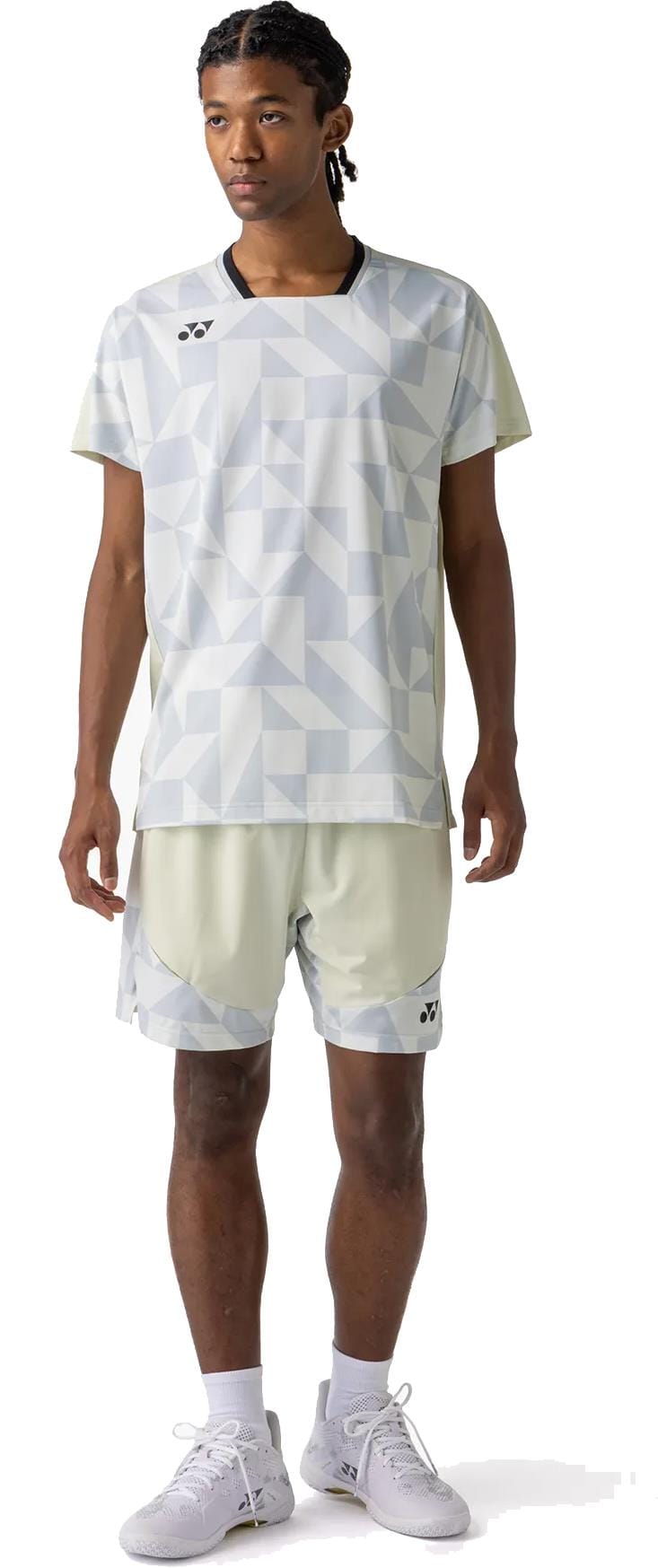 A person stands facing forward, wearing the Yonex 10712YX Crew Neck Men's Padel T-Shirt in Champagne—a light-colored, quick-drying Yonex shirt—paired with matching shorts, white socks, and white athletic shoes.