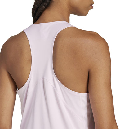 A person with braided hair is wearing the adidas Women's Club Padel Tank Top - Pink. Made from recycled materials, this sleeveless top features a racerback style that highlights its fit and Climacool texture from the back.