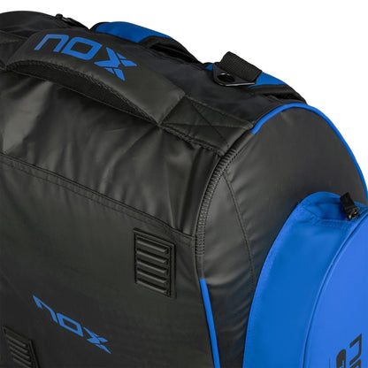 Close-up of the NOX ML10 Team Padel Racket Bag in black and blue, featuring "NOX" branding, a sturdy handle, zippered compartment, and ventilation holes for airflow.