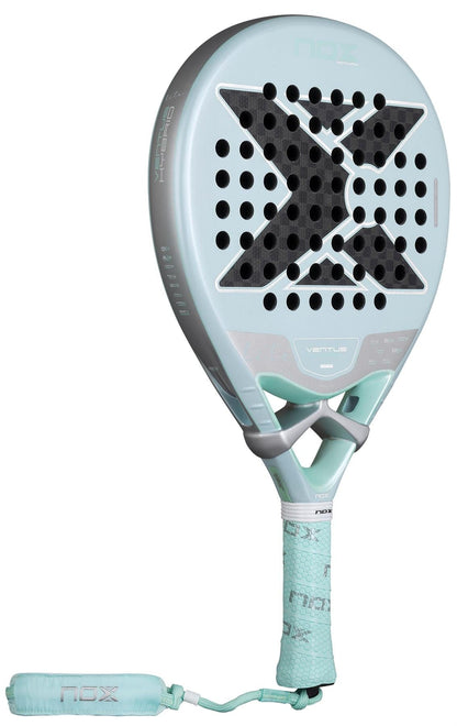 The NOX Luxury Ventus 12K Hybrid Lite 2026 Padel Racket in blue features a large black X on its 12K carbon fibre face with circular holes, plus a matching padded wrist strap attached to the handle.