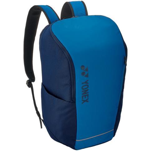 The Yonex 42312SEX Team Padel Backpack, ideal for racket sports, boasts a vibrant sky blue and black design with comfortable padded shoulder straps. It is equipped with a front zipper pocket, side pockets, and features the Yonex logo printed vertically on the front.