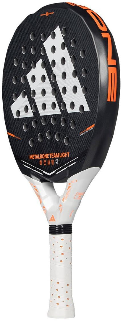 The adidas Metalbone Team Light 2026 Padel Racket in black features orange accents, a large adidas logo, round face perforations, and a white grip. Designed for advanced players.