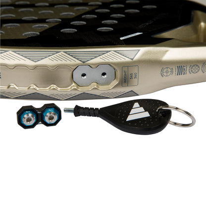 Close-up of the ADIDAS Metalbone CTRL 3.4 Padel Racket, Gold edition by adidas, featuring a textured surface, dual detachable weights with an Allen key for its Weight & Balance System. An octagonal structure provides precision, while the logo and weight specs are displayed on a keychain.