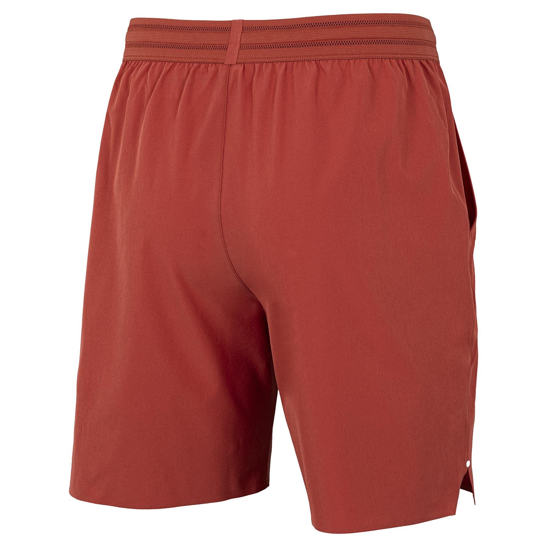 The Tecnifibre Team Stretch Men's Padel Shorts in terracotta feature a minimalist design with an elastic waistband, side seams, and comfortable stretch fabric, shown here from the back.