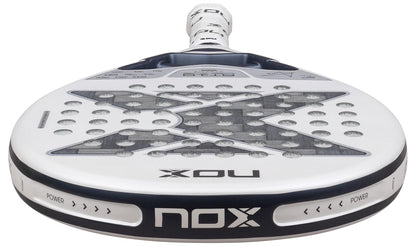 Close-up of the NOX AT10 Genius 12K Alum Extrem Lite By Agustín Tapia 2026 padel racket, mainly white with black details, bold "X" design, and visible NOX branding highlighting its advanced weight balance system.