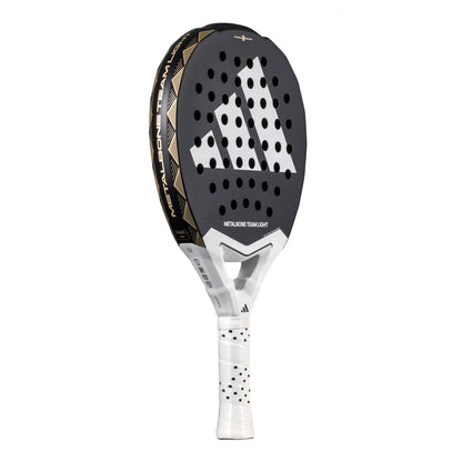 The ADIDAS Metalbone Team Light 3.4 Padel Racket by adidas, in black and white, features a geometric pattern with diagonal white stripes at its center. Designed for advanced players, it has a lightweight build and a white grip with black polka dots, making it an exceptional choice.