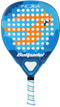 The Bullpadel INDIGA Junior Boys 2026 padel racket for kids features a blue design with an orange cartoon dragon (horns and wings) on a wavy blue background with white dots. Brand: Bullpadel.