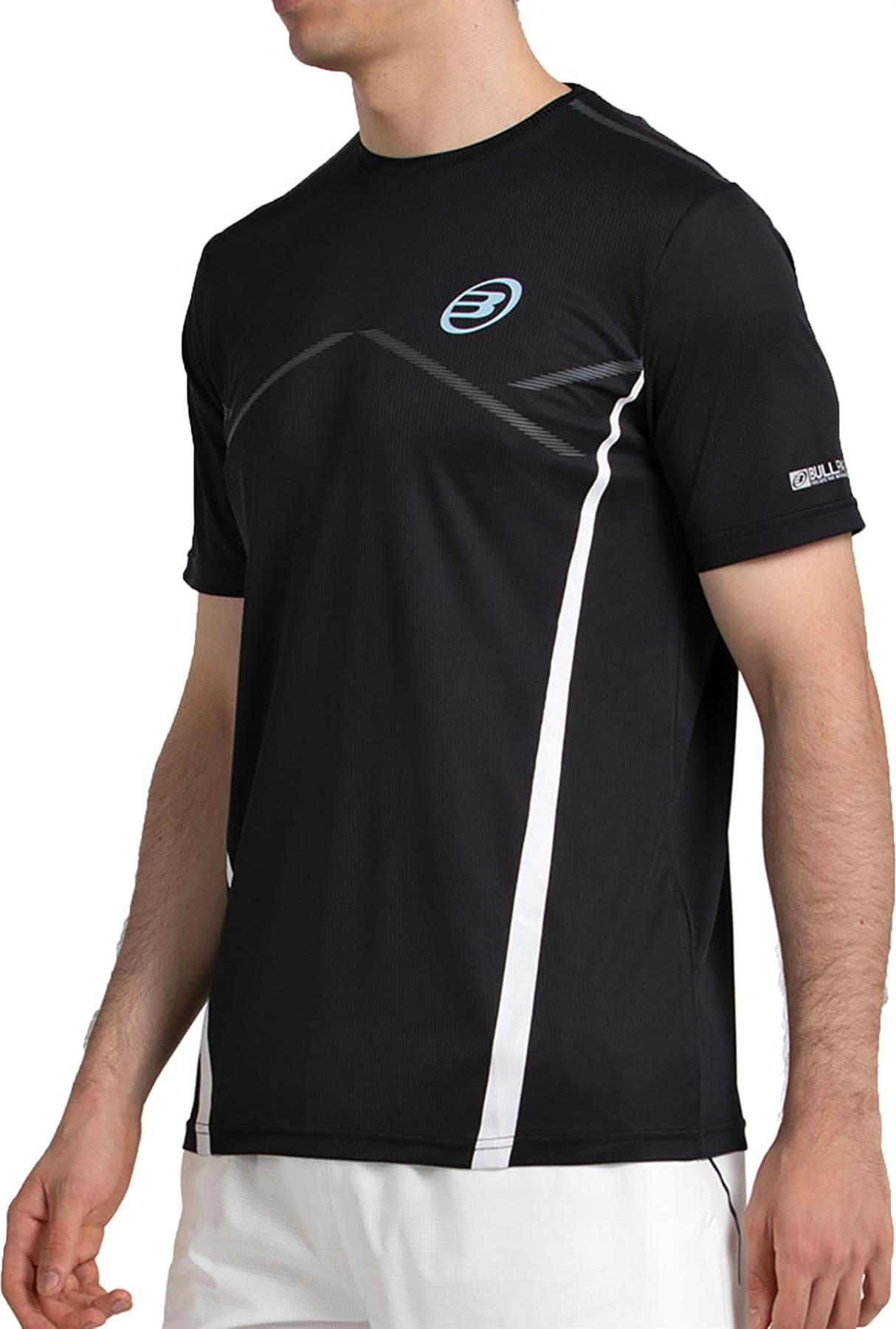 A man wears the Bullpadel Cabore Men's Padel T-Shirt in black by Bullpadel, featuring white accents and a small circular chest logo, paired with white shorts.
