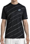 A man wears the Bullpadel Casinas Men's Padel T-Shirt in black, featuring diagonal white stripes and a small circular logo, made from lightweight polyester with Quickerdry technology, paired with white shorts against a plain background.