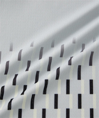 A silver grey Yonex 10713EX crew neck men's padel T-shirt features a diagonal drape and a pattern of black and off-white vertical rectangular shapes in staggered rows.