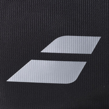 A close-up of the Babolat RH Perf Padel 2nd Gen Backpack in Black/Silver, showing its textured black surface and the white minimalist Babolat logo with two diagonal stripes, echoing its signature high-performance padel bag design.