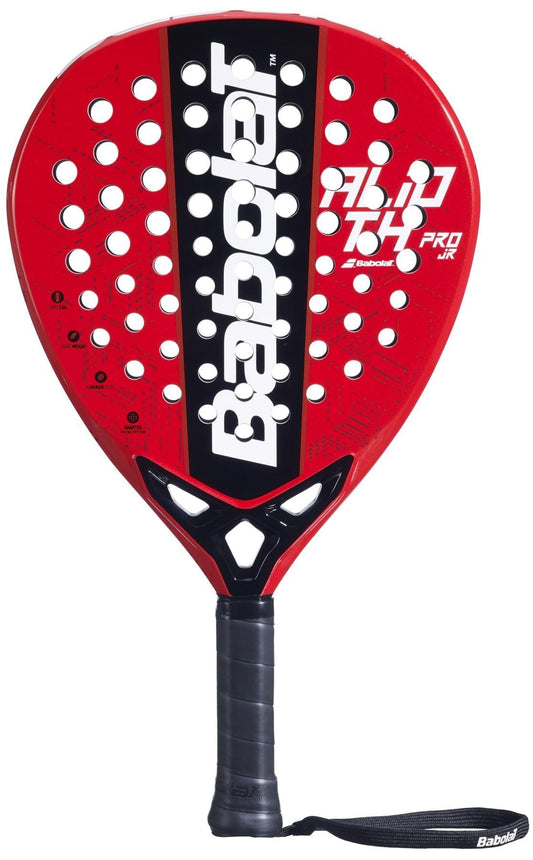 The Babolat Alioth Pro Junior Padel Racket in red and black features multiple circular holes, a black grip handle with a wrist strap, and displays the Babolat brand name prominently in white.