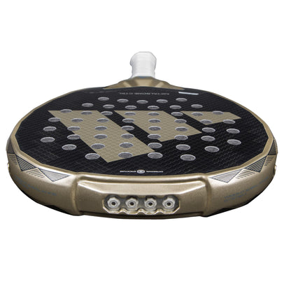 Close-up of the ADIDAS Metalbone CTRL 3.4 Padel Racket - Gold, featuring a gold frame and black face with circular holes, enhanced by an Octagonal Structure. The handle has white grip tape, and the adidas logo is prominently displayed on its surface.