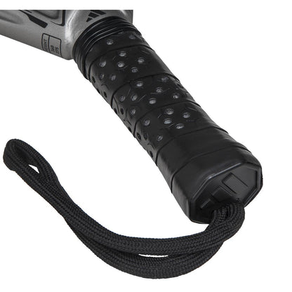 A close-up of a black textured rubber handle grip with a ridged pattern is attached to a black cord loop, evoking the adidas Adipower Carbon Light 3.4 Padel Racket design, featuring Carbon 3K Fibre and a metallic silver section visible at the upper edge.