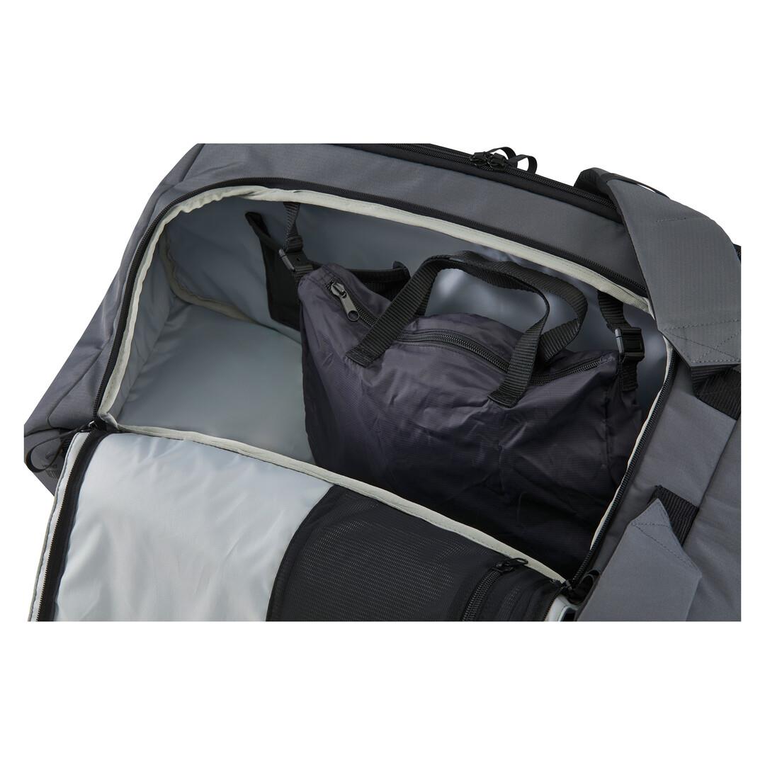 A partially open gray travel bag reveals a zippered compartment, holding a black and dark grey HEAD Pro X Duffle Padel Bag L with handles. The empty main section showcases light gray lining made from recycled PET bottles.