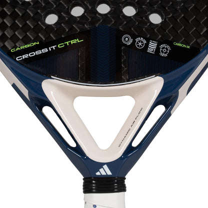 Close-up of the ADIDAS Cross It Carbon CTRL Padel Racket with "CROSS IT CTRL" branding in white and green on a black surface. Featuring Carbon 6K for control, the handle has an elegant navy and white design. Various symbols emphasize its durability and softness.