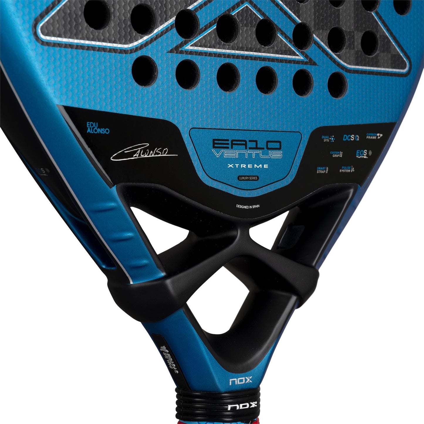 Close-up of the NOX Luxury EA10 Ventus Attack 12K XTREM By Edu Alonso 2026 padel racket in blue and black, showing the brand NOX, model details, 12K XTREM Carbon design, and multiple logos on the racket head.
