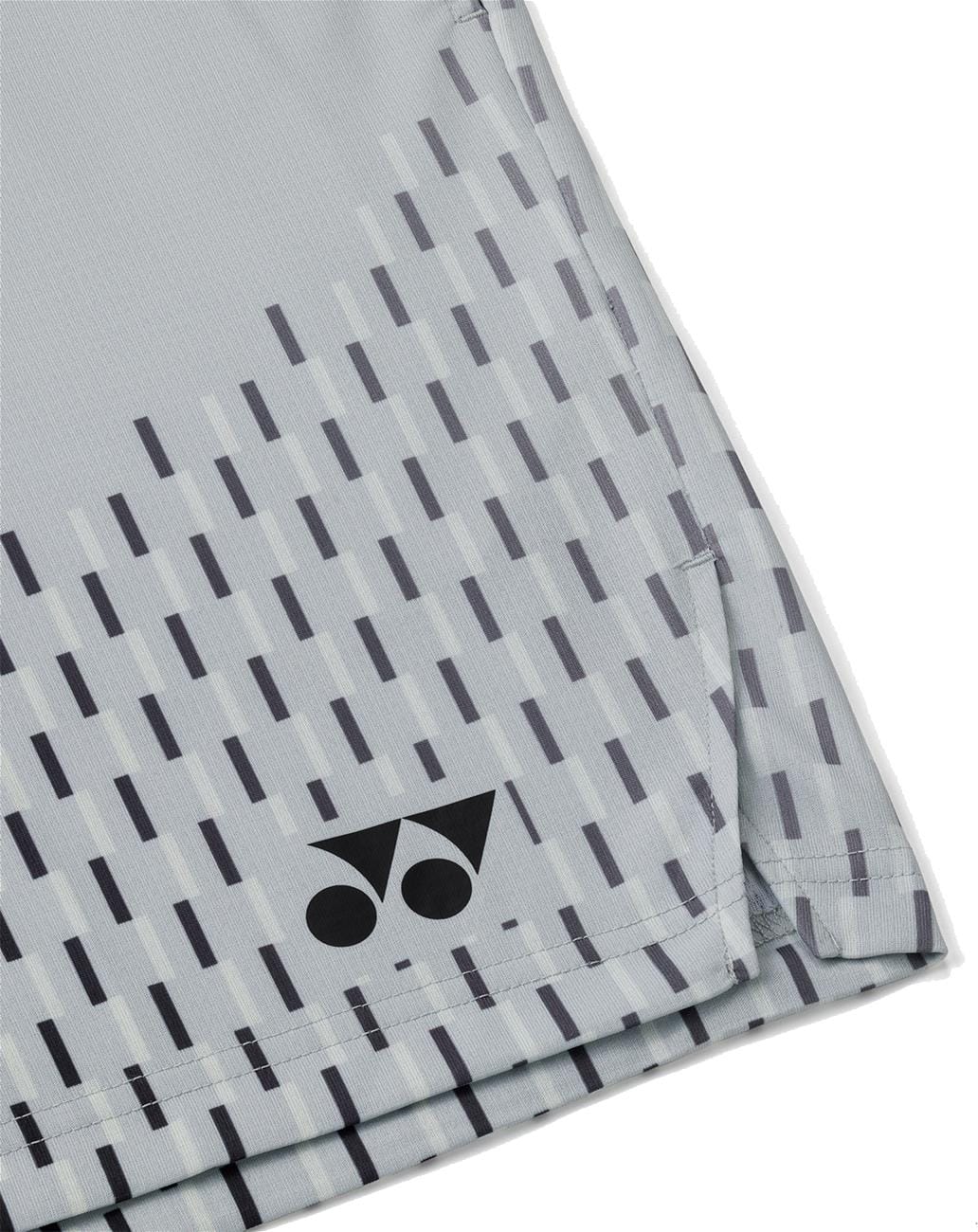A close-up of Yonex 15241EX Knit Men's Padel Shorts in Silver Grey shows diagonal dark gray lines and the Yonex logo—two dots and a triangle—in black at the hem, offering moisture-wicking comfort for high performance.