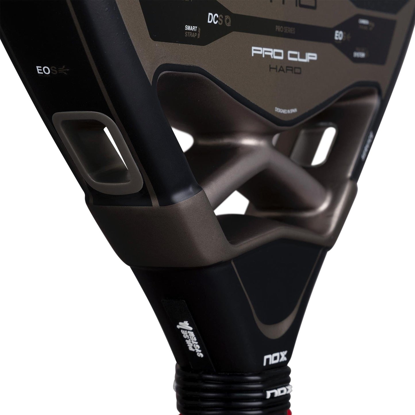 Close-up of the throat area of the NOX AT10 Pro Cup Hard By Agustín Tapia 2026 padel racket, showing NOX logos, holes, and part of the handle with wrist strap. The black metallic surface features white and gold accents.