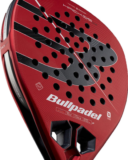 Close-up of a red Bullpadel Hack 05 Comfort 2027 Padel Racket, featuring its perforated surface, prominent Bullpadel logo, and textured frame details. The image also highlights the advanced MultiEva core and Tricarbon 18K construction designed for superior performance.
