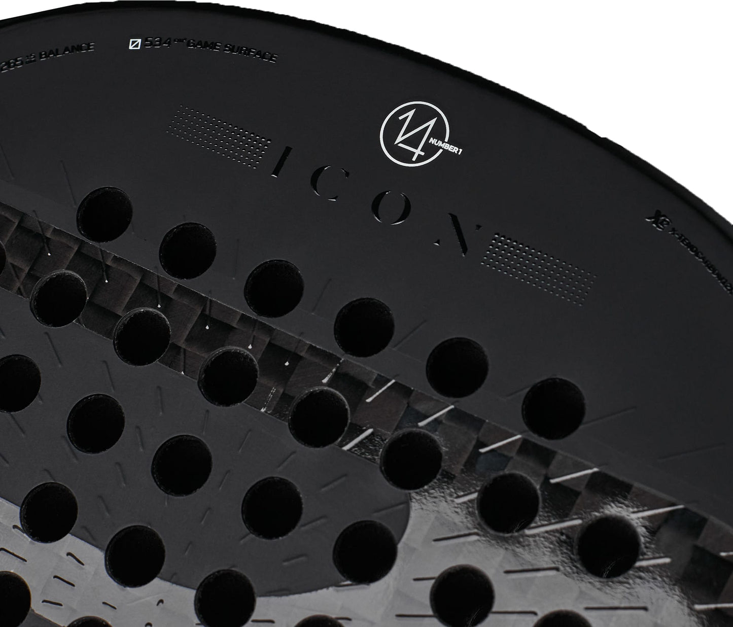 Close-up of a black Bullpadel Icon 2027 Padel Racket with round holes, highlighting the word “ICON” and a circular Bullpadel logo near the top edge. Constructed with X-Tend Carbon 12K and a MultiEva core for superior performance.