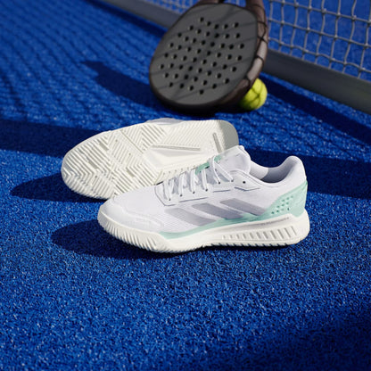 ADIDAS Courtquick Womens Padel Shoes in Cloud White/Silver Metallic/Clear Mint by adidas are shown on a blue tennis court with a paddle and balls, showcasing stylish, quality padel footwear for your next match.