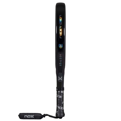 The NOX NextGen Pro Attack 12K NFA 2026 Padel Racket features a black diamond head, "NEXTGEN" vertically on the side, a NOX logo by the handle, and a branded wrist strap attached to the bottom.