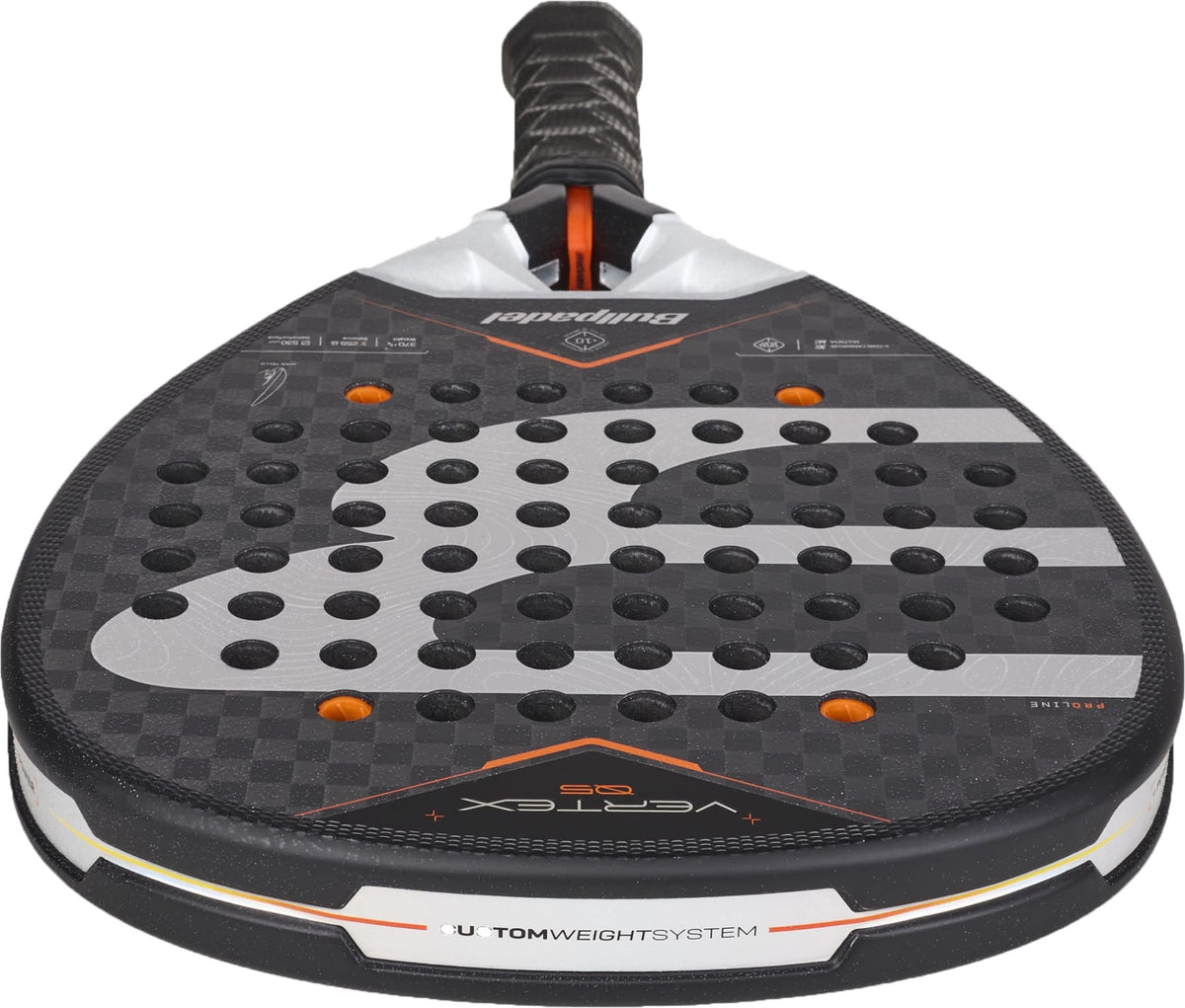 A close-up of the Bullpadel Vertex 05 2027 Padel Racket highlights its black and orange design with a perforated face, complemented by gray and white accents. Visible branding includes “VERTEX” and “CUSTOM WEIGHT SYSTEM” near the base. The racket’s premium construction showcases Bullpadel’s X-Tend Carbon 12K technology.