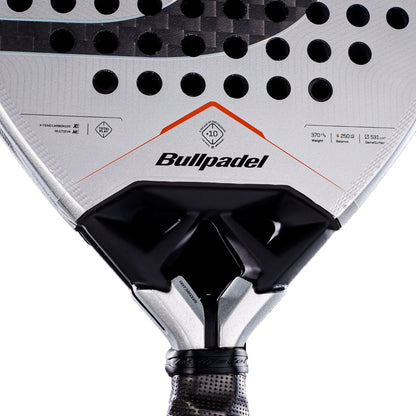 Close-up of a Bullpadel Vertex 05 Hybrid 2027 Padel Racket, displaying the Bullpadel brand name, circular holes, and technical specifications on its silver and black surface near the handle. The image emphasizes the racket’s hybrid head shape and advanced MultiEva core for enhanced performance.