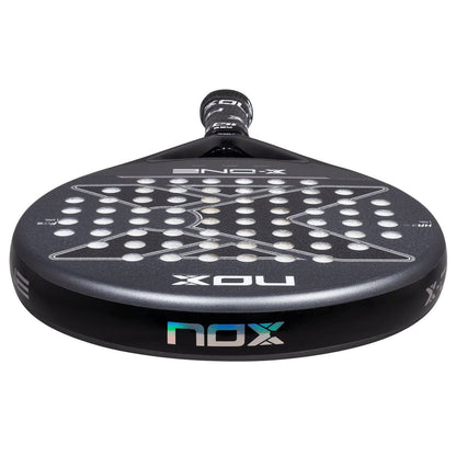 Close-up of the NOX X-One 2026 Padel Racket, displaying its perforated face with circular holes and NOX logos—perfect for beginner players wanting enhanced control.